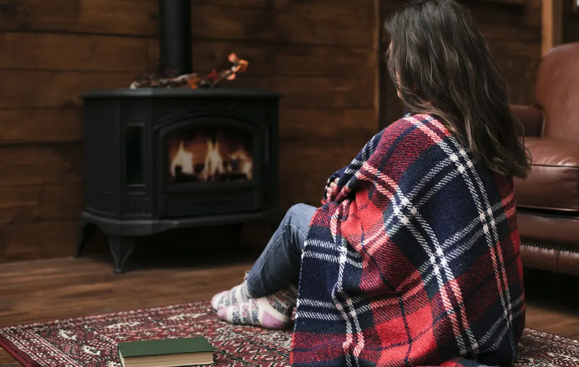 Žena se grije uz peć